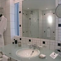 La salle de bain bénéficie de la lumière du jour grâce à deux fenêtres (dont les vitres s'opacifient à la demande) qui donnent sur le coin bureau.