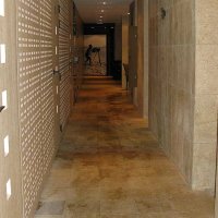 Granit et bois clair, la coursive qui mène aux douches, toilettes, hammam et sauna