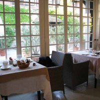 Salle du petit-déjeuner : de l'autre côté de la cour fleurie, la salle du restaurant