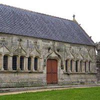 Enclos paroissial de Pleyben - Vus du sud-est : l'ossuaire de style gothique flamboyant (1560, restauré en 1733, bénit en 1736 et convertit en chapelle des morts, "chapelle des Trépassés", et dédiée à saint Simon et saint Jude) et la porte triomphale (1725) 