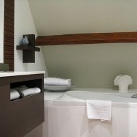 La salle de bain : meuble lavabo design, baignoire et douche.