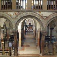 Verone – San Zeno Maggiore – l’accès à la crypte par l’escalier conçu au XIXe siècle - Voussures des arcades sculptées par d’Adamino da San Giorgio (XIIIe siècle) – au fond de l’abside, l’urne contenant le corps de l’évêque saint Zénon (San Zeno), patron de Vérone.